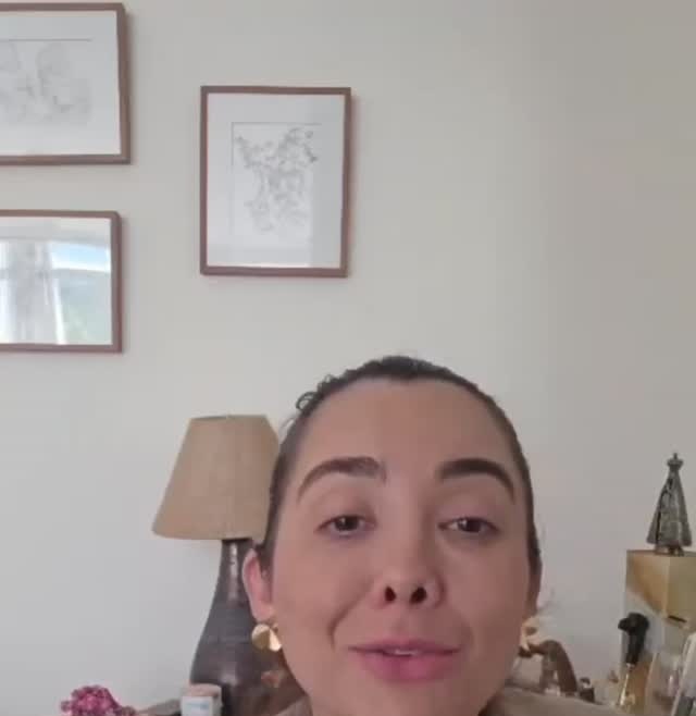 Mariana em uma sala com quadros e abajur.