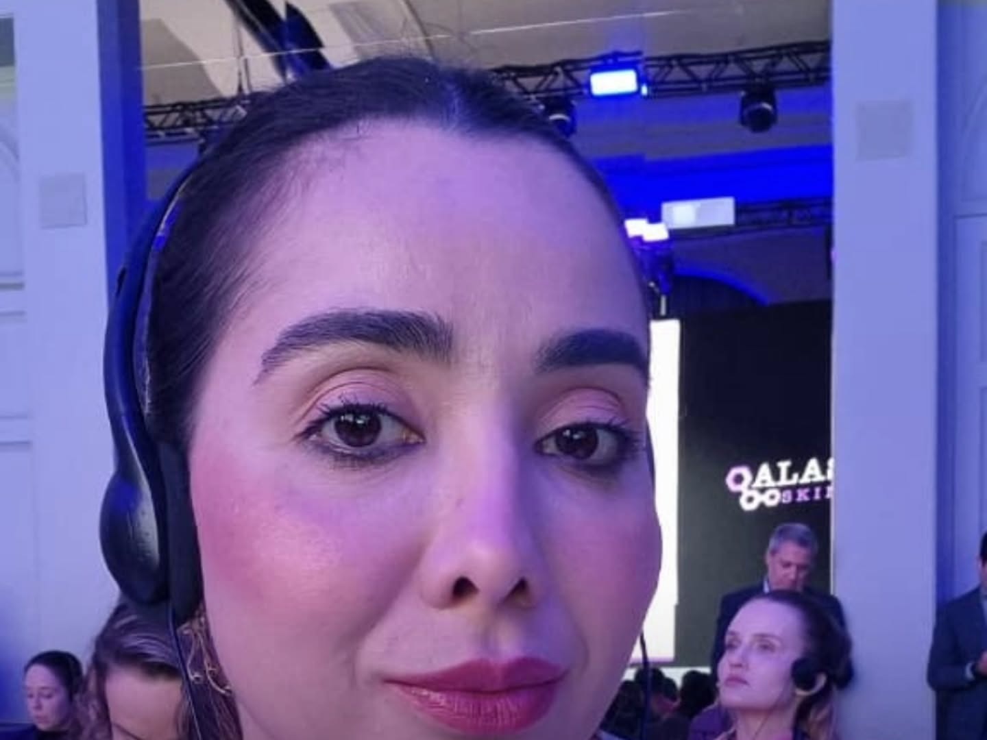 Mariana em um retrato sob iluminação azul e roxa.